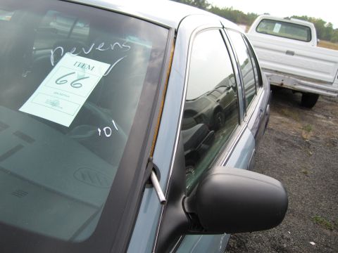 1991 Ford LTD Crown Victoria - Auction tag on windshield of a car, with a white pickup truck visible in the background.