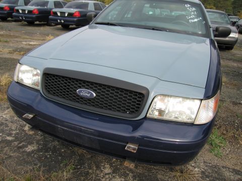 1991 Ford LTD Crown Victoria - Two-tone Ford Crown Victoria with push bumper mounts visible on the front bumper.