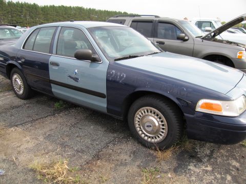 1991 Ford LTD Crown Victoria - A sedan with a dark blue and light blue two-tone paint scheme sits in a lot next to other vehicles.