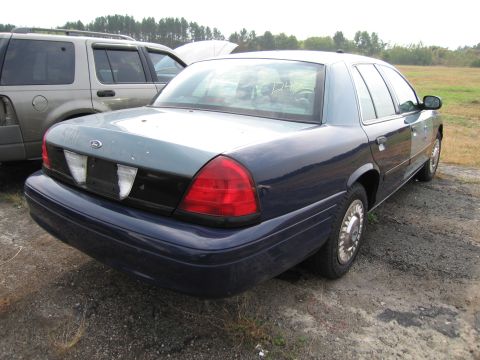 1991 Ford LTD Crown Victoria - A dark blue Ford Crown Victoria sedan is parked outdoors next to another vehicle.