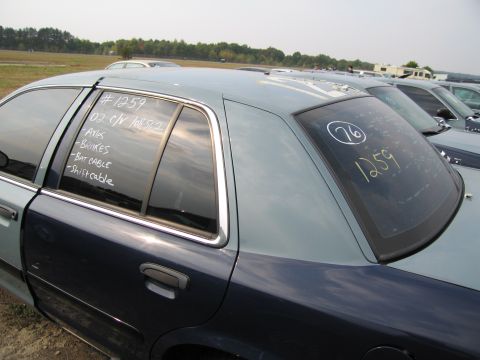 1991 Ford LTD Crown Victoria - A Ford Crown Victoria is parked in a lot with other vehicles, showing handwritten notes on the window.