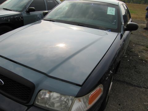 1991 Ford LTD Crown Victoria - A blue Ford Crown Victoria is seen from a 3/4 front angle, parked outdoors next to another vehicle.