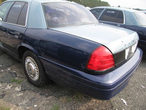 1991 Ford LTD Crown Victoria - A two-tone sedan is parked in a lot with another similar vehicle visible behind it. Text is written on the rear windows.
