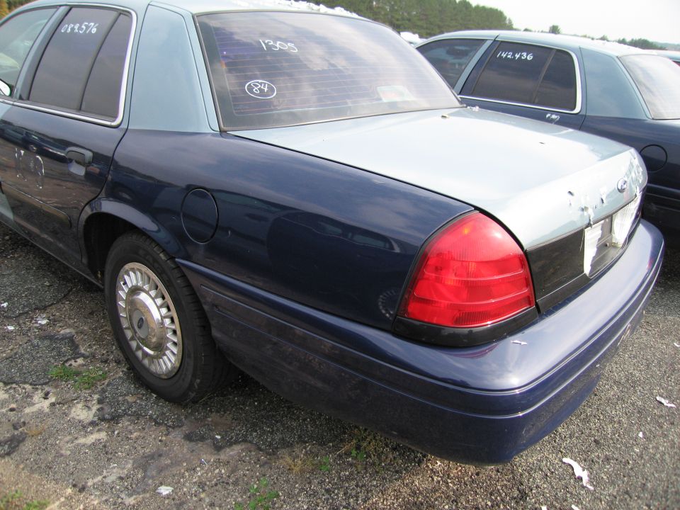 Rear view of a two-tone sedan with a dark blue lower half and light blue upper half. Text on rear window