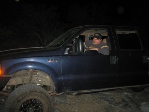 1994 Ford Bronco - A man sits in the driver's seat of a blue Ford F-250 Super Duty truck at night.