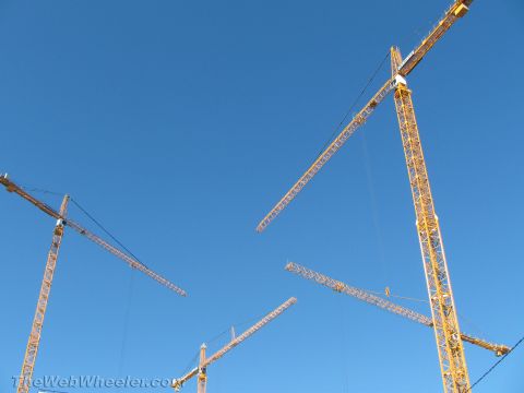 1968 Ford Mustang - Several tall construction cranes are visible against a bright blue sky.