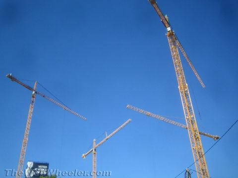1968 Ford Mustang - Multiple construction cranes are visible against a clear blue sky, with a billboard in the distance.
