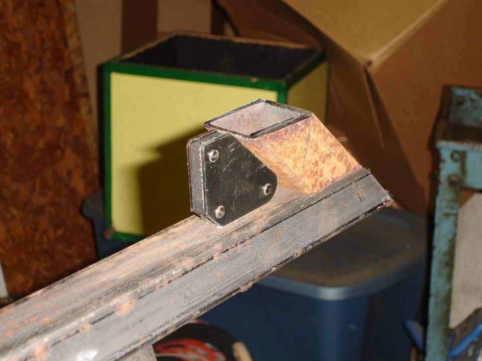 Rusty metal bracket attached to a square tube frame
