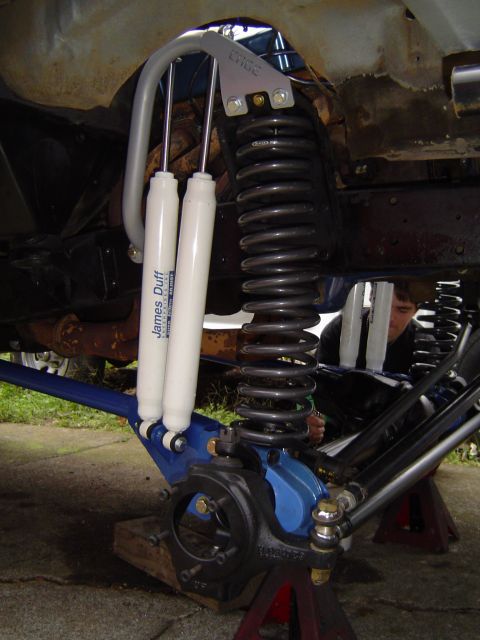 1978 Ford Bronco - Close-up of a vehicle's modified front suspension system with dual shock absorbers.