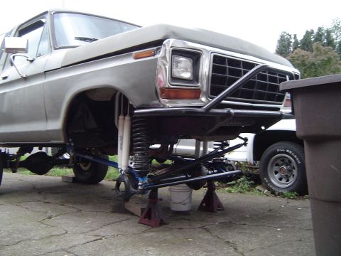 1978 Ford Bronco - A 1978 Ford Bronco is shown with its front end elevated on jack stands, revealing custom suspension components.