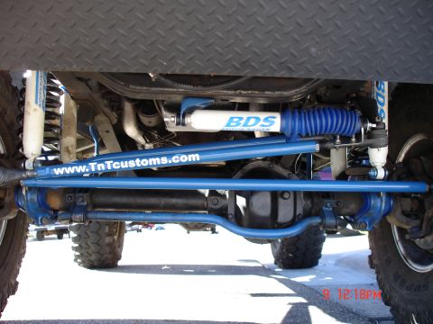 1979 Ford Bronco - Undercarriage view showing blue suspension components and BDS shocks, with website text visible.