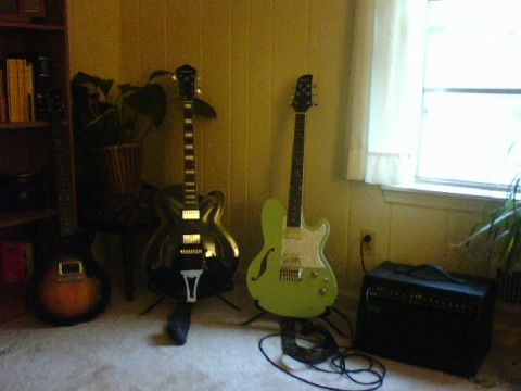 1995 Ford Bronco - A collection of electric guitars and an amplifier are set up indoors near a window.