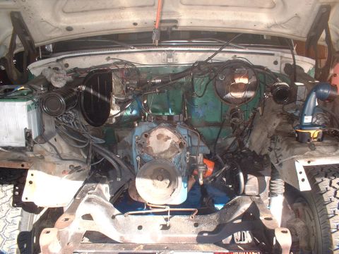 1978 Ford Bronco - The engine bay of a vehicle is exposed, revealing the engine and various mechanical parts.
