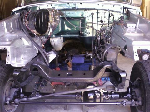 1978 Ford Bronco - The front end of a vehicle is disassembled, revealing the chassis and engine bay.