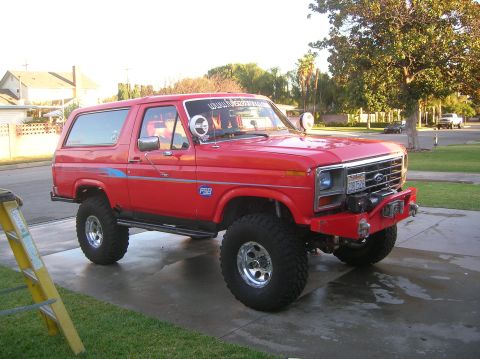 1985 Ford Bronco - This modified Ford Bronco features a lifted suspension and off-road tires, suggesting a model year earlier than claimed.