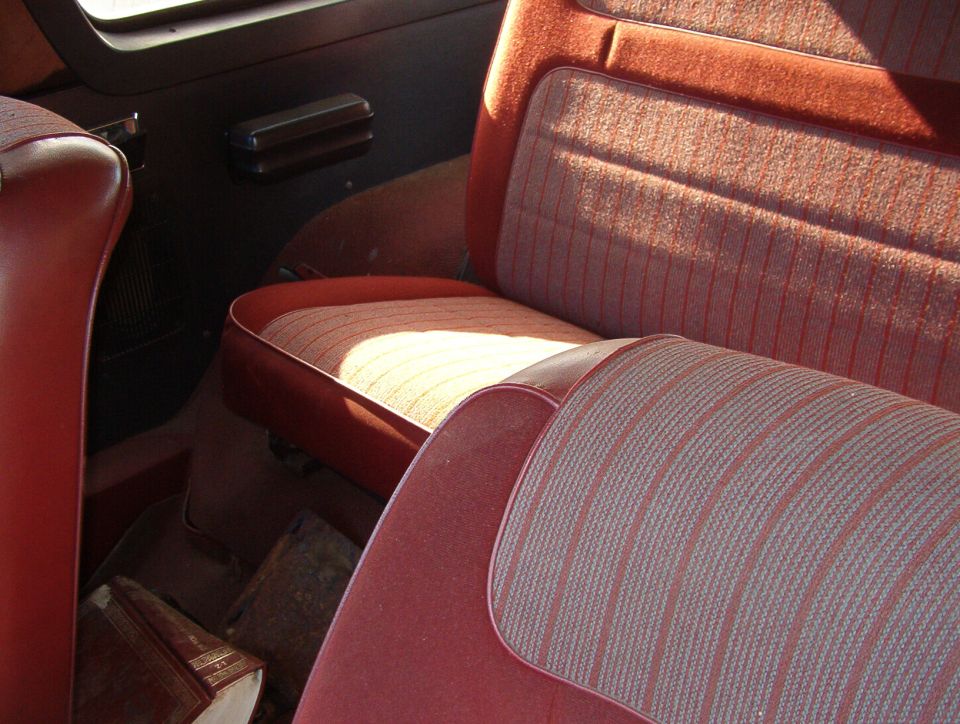 Red cloth and vinyl bench seats inside a truck