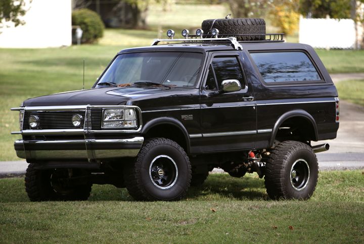 Black lifted Ford Bronco SUV, front three-quarter view with roof rack and off-road tires