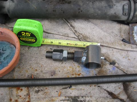 1990 Ford F-250 - A metal assembly with threaded rod and nuts is measured with a Stanley tape measure.