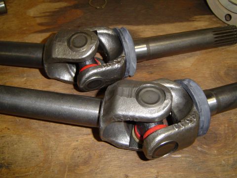 1978 Ford Bronco - Close-up view of two front axle shafts, each a U-joint with visible red and white seals.