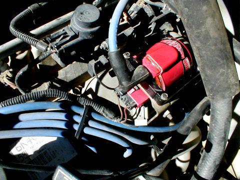 1996 Ford Bronco - This is a close-up view of an engine's ignition system, a red MSD ignition coil and blue spark plug wires.