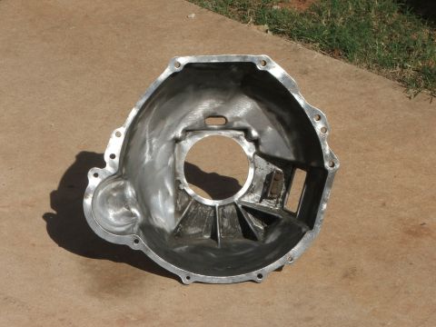 1965 Ford Mustang - Aluminum bell housing part shown on concrete surface.