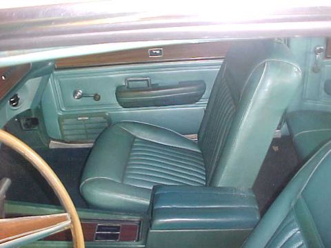 1969 Ford Torino - Interior view of a 1969 Ford Torino, highlighting the teal vinyl seating and door panel details.
