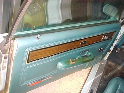 1969 Ford Torino - The interior door panel of a 1969 Ford Torino shows teal vinyl and wood grain trim.