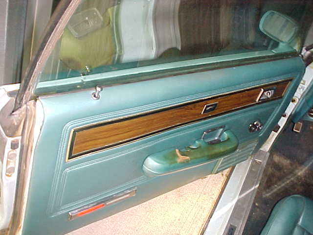 1969 Ford Torino interior door panel with wood trim and teal vinyl