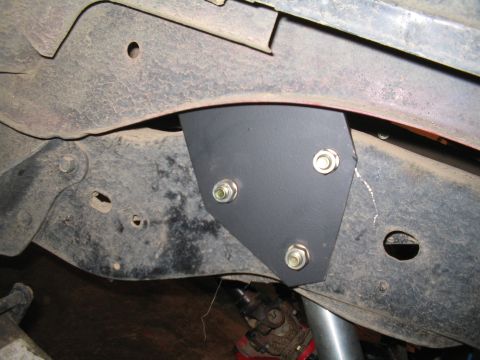 1989 Ford Bronco - Aftermarket shock mount bracket installed on a vehicle's frame, showing a close-up of the hardware and chassis.