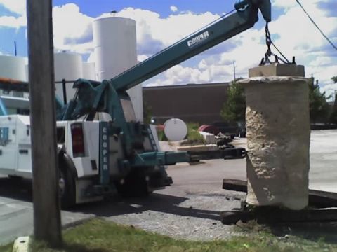 1992 Ford Bronco - A Cooper tow truck is shown lifting a large concrete pillar from the ground.