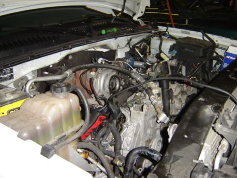 1992 Ford Bronco - Close-up view of a vehicle's engine compartment, showing various mechanical components and fluid reservoirs.