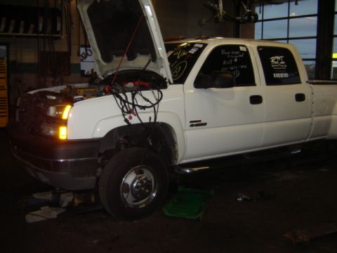 1992 Ford Bronco - A white pickup truck is shown with its hood open, revealing exposed wiring, and has handwritten notes on its windows.