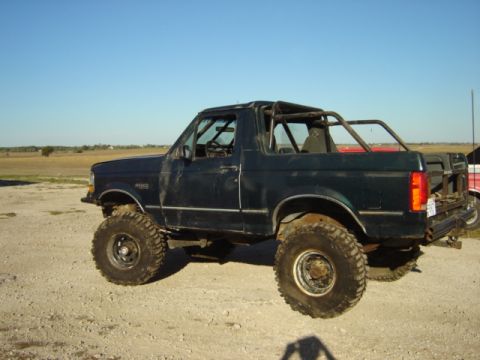1992 Ford Bronco - This 1992 Ford Bronco features off-road tires and a custom roll cage, seen from the side.