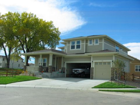 1995 Ford Bronco - A suburban house with a driveway leading to an open garage where a truck is parked.