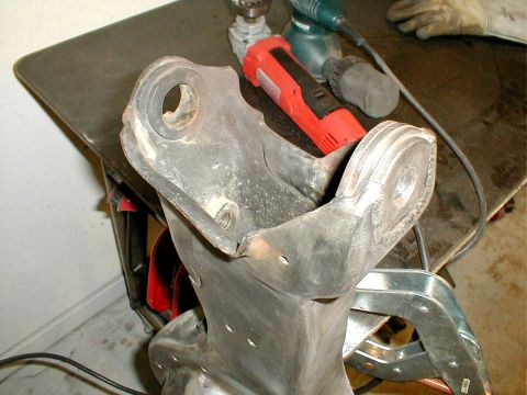 1996 Ford Bronco - Close-up of a vehicle suspension part with power tools in the background.