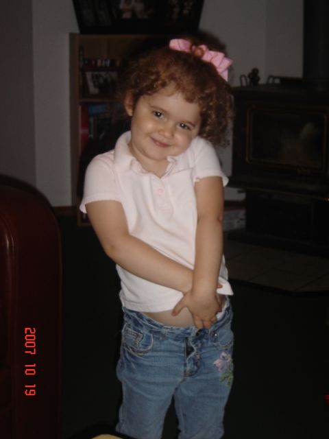 1993 Ford Bronco - A young child with curly red hair smiles shyly while posing for a photo indoors.