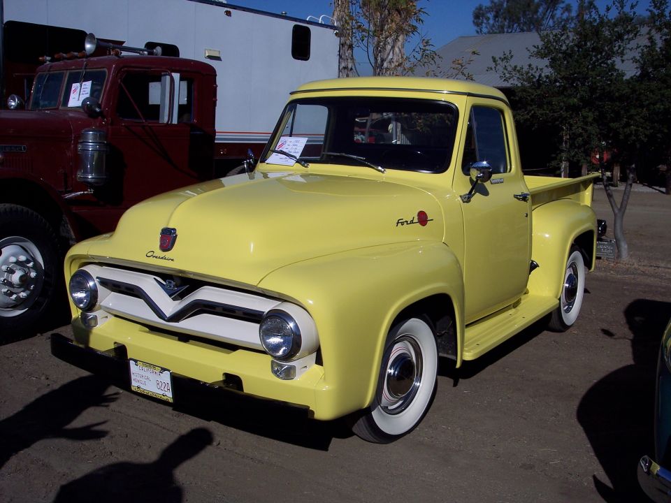 Yellow 1953 Ford F-series pickup truck with a white grille and wide whitewall tires