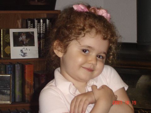 1993 Ford Bronco - A young child with curly hair and a pink bow in her hair smiles at the camera.