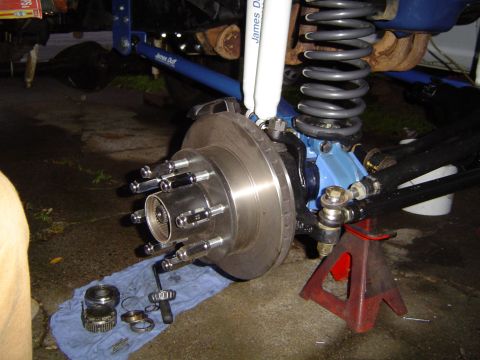 1978 Ford Bronco - Close-up of a vehicle's front wheel hub assembly, showing suspension components and brake rotor.
