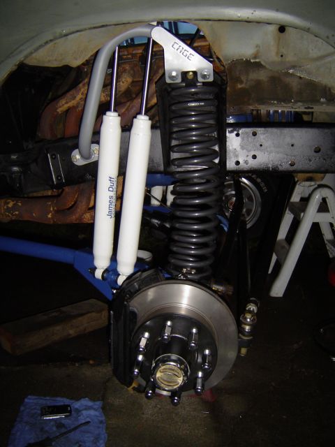 1978 Ford Bronco - Close-up of a vehicle's front suspension system, dual shock absorbers and a heavy-duty coil spring.