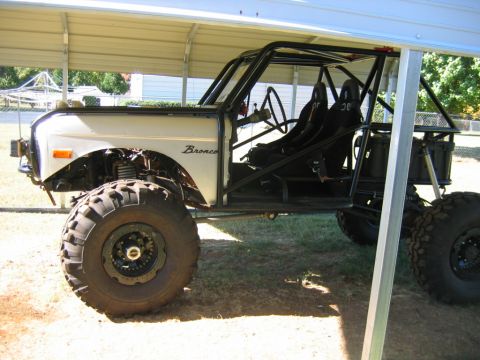 1992 Ford Mustang - This custom off-road vehicle, identified as a Bronco, features a prominent roll cage and oversized tires, suggesting significant modificati…