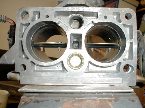 1996 Ford Bronco - This is a close-up view of a throttle body, a component of the engine's air intake system.