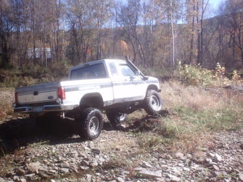 1990 Ford Ranger - Lifted 1990 Ford Ranger navigates a rocky, off-road trail during autumn.