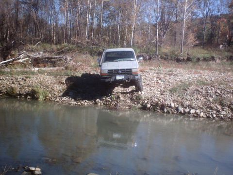 1990 Ford Ranger - A gray Ford Ranger is parked on a rocky bank next to a body of water.