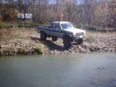 1990 Ford Ranger - Lifted 1990 Ford Ranger parked on a rocky bank by the water.