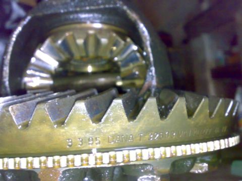 1995 Ford F-150 - Macro shot of a Dana differential ring gear meshed with the pinion, casting numbers '3.3.05 DANA T 38803' visible on the gear face.
