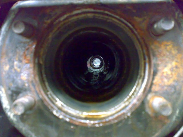 Close-up view into a rusted metal tube with a bolt visible at the end
