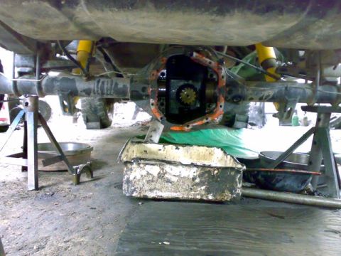 1995 Ford F-150 - The rear axle differential is exposed for maintenance, with a drain pan positioned below.