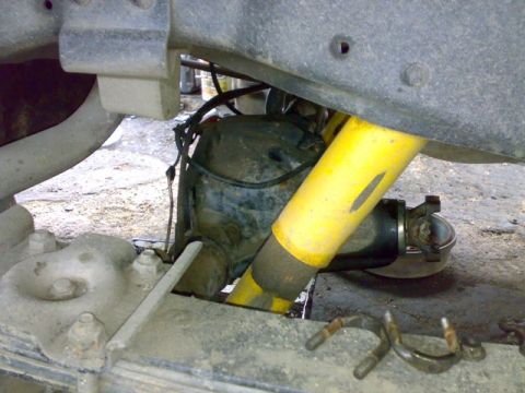 1995 Ford F-150 - Close-up view of a rear axle assembly, a yellow shock absorber and leaf springs, with visible text from SuperMotors.net.