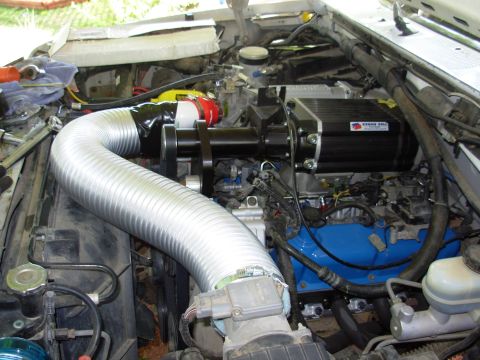 1994 Ford Bronco - Engine bay shows a supercharger installation with a prominent silver intake hose and blue engine components.